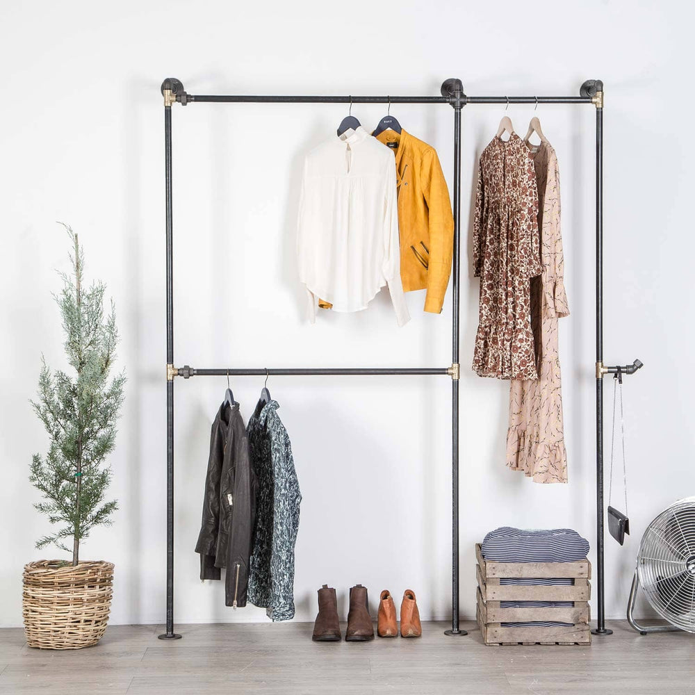 Rustikt tøjstativ af rå sorte vandrør med messing fittings som sættes fast i væggen og udnytter gulvpladsen. Plads til hele garderoben med en høj bøjlestang som kan bruges til kjoler. Går rigtig godt i en rustik indretning